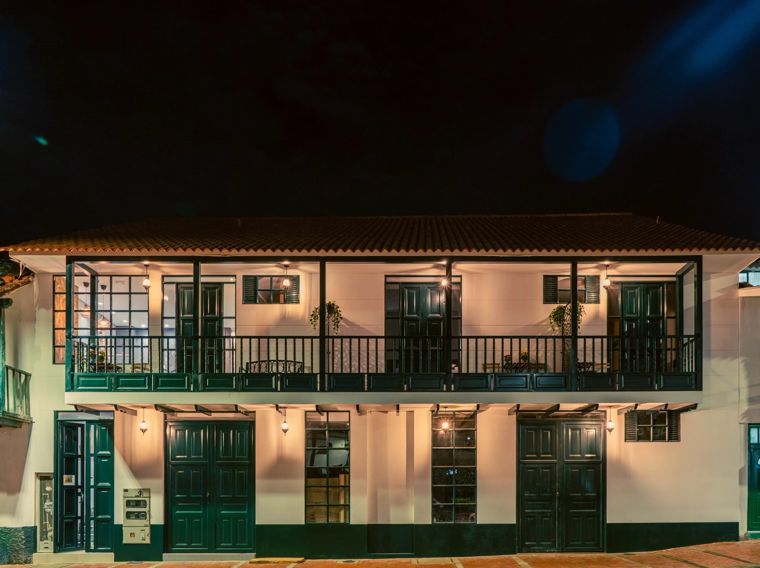 La casona de balcones iluminada de noche